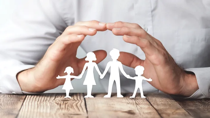 Hands on table making an arch over an outline drawing of a stick family