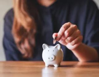 Woman placing money into a piggy bank