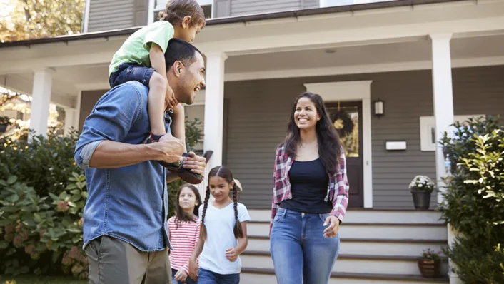 Una familia joven en frente de la casa.