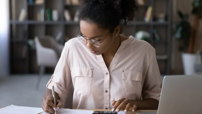 A young adult working on filling out paperwork for student loans