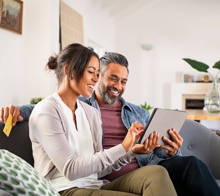 couple looking at tablet on the couch