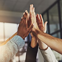 A group of people high-fiving each other at once