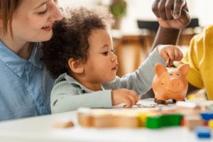 mother and child playing with piggy bank toy