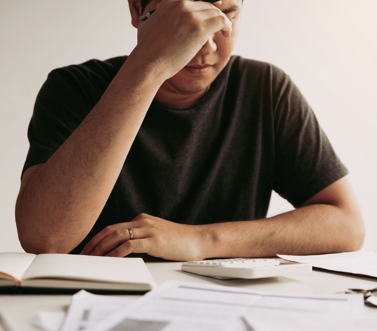A stressed man looking over financial statements
